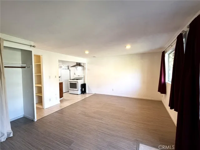 This bright studio-style space features an open living area with wood-style flooring, recessed lighting, and a large closet for storage.