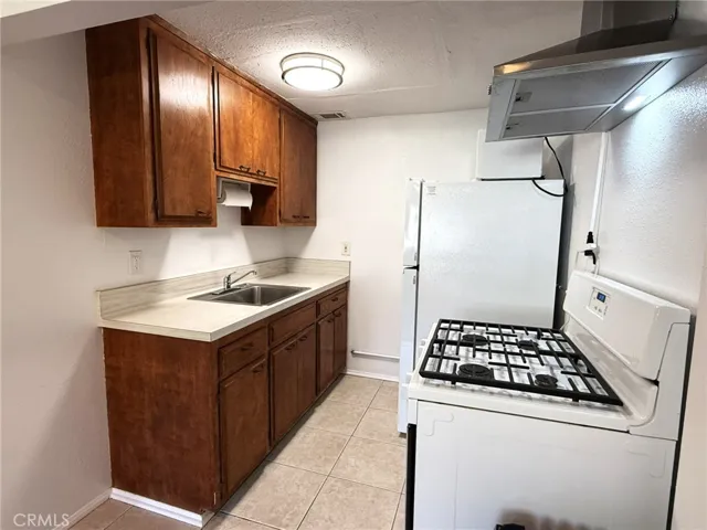 The kitchenette includes a gas range, sink, refrigerator, microwave, and cabinetry for convenient everyday living.