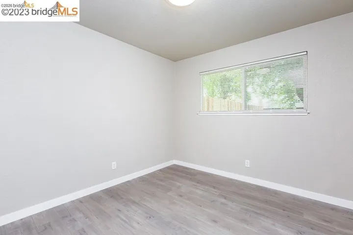Spare room featuring light wood-type flooring and baseboards