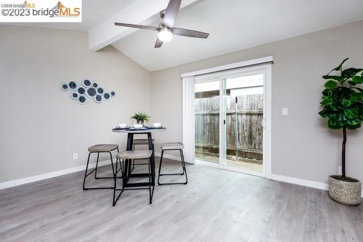 Dining space featuring vaulted ceiling with beams, light wood-style floors, and ceiling fan