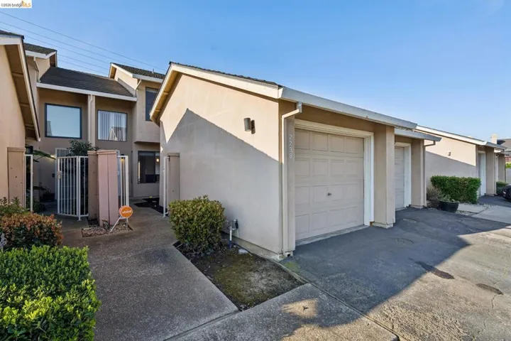 Mid-century inspired home featuring stucco siding, concrete driveway, and a garage