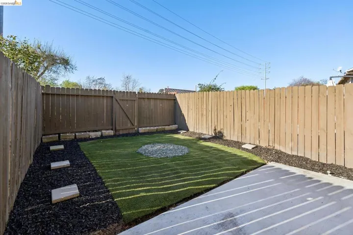 Fenced backyard featuring a gate
