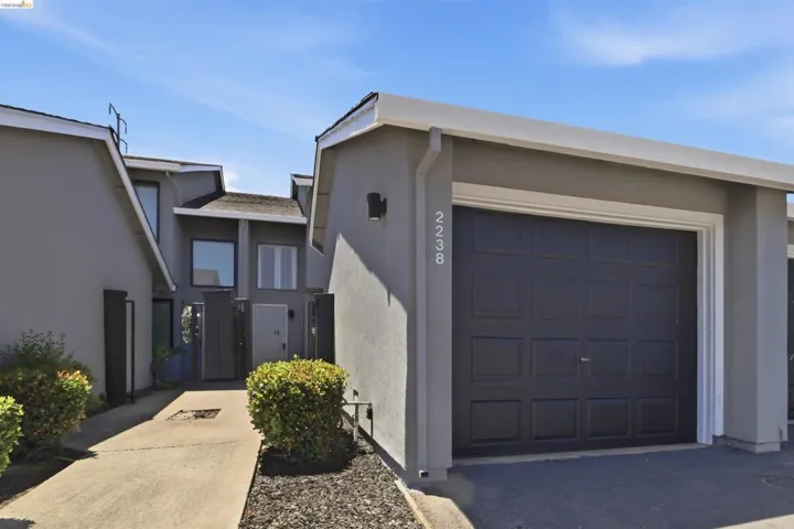 Single-car garage with a paneled door and recessed wall sconce