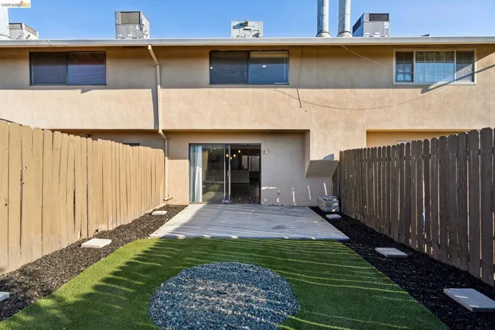 Rear view of property featuring stucco siding and a fenced backyard