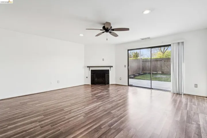 Unfurnished living room with recessed lighting, a fireplace, dark wood finished floors, and ceiling fan