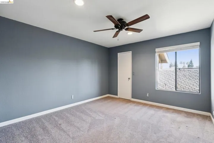 Empty room featuring light carpet, ceiling fan, and recessed lighting