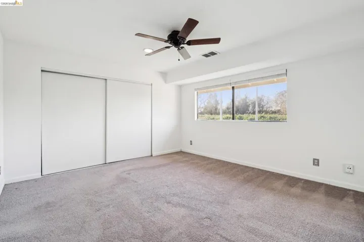 Unfurnished bedroom featuring carpet floors, a closet, and ceiling fan