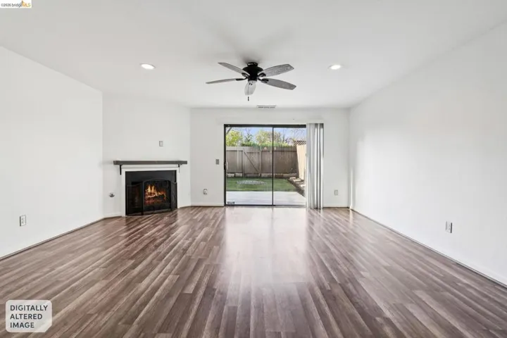 Unfurnished living room with dark wood-style floors, a ceiling fan, a lit fireplace, and recessed lighting