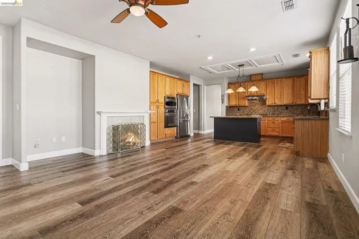 Kitchen featuring pendant lighting, open floor plan, a center island, ceiling fan, and stainless steel appliances