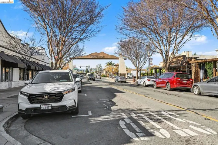 View of asphalt street with curbs, sidewalks, and street lights