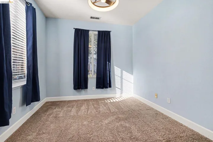 Spare room featuring light colored carpet and baseboards