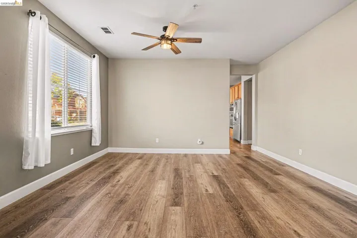 Empty room with ceiling fan and light wood finished floors