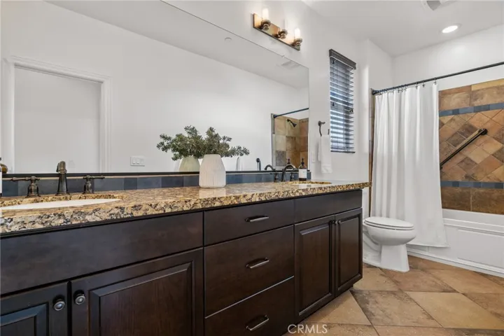 Upstairs guest bathroom has dual sinks and shower/tub.