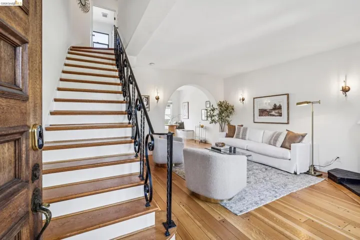 Living room with hardwood / wood-style floors, arched walkways, and plenty of natural light