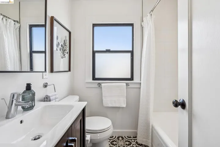 Full bath featuring vanity, shower / bath combo, and tile patterned floors