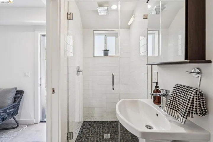 Full bathroom with a shower stall, vaulted ceiling, and tile patterned flooring