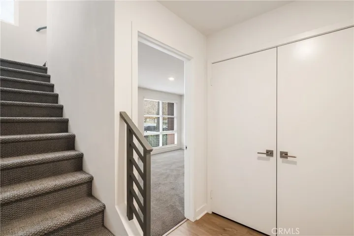Stairs leading up to main level and entry way to Bedroom 4 (2 door - Walk in coat closet)