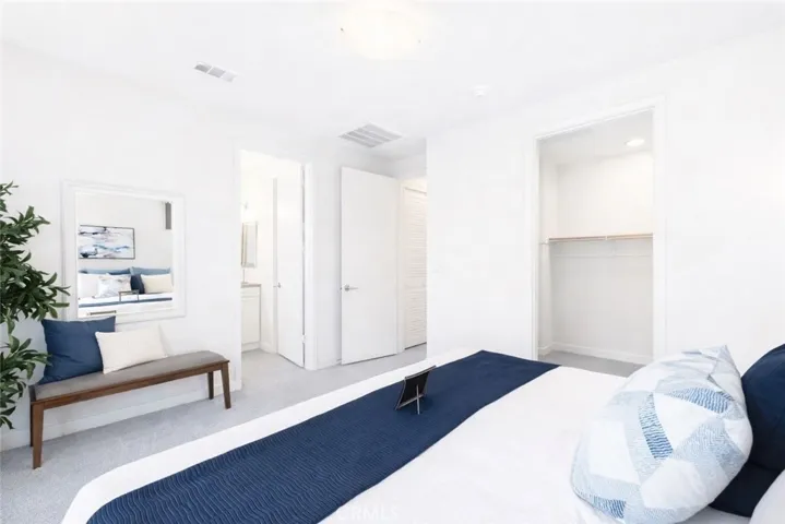 Digitally staged primary bedroom PHOTO 2 & walk in closet