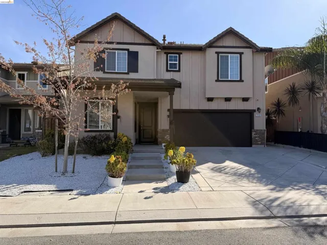 View of front facade featuring a garage, driveway, and brick siding