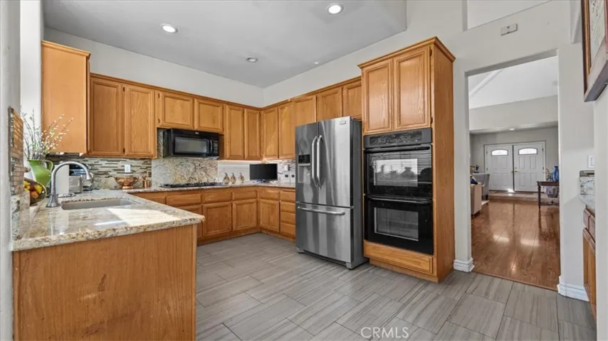 The spacious kitchen offers abundant cabinetry, granite countertops, and stainless steel appliances, with a functional layout designed for efficient meal preparation.