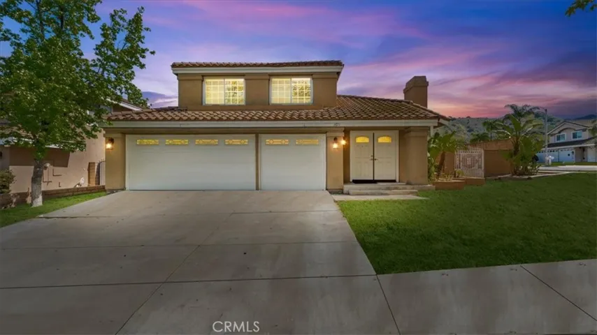 This well-maintained home features a spacious three-car garage, a wide driveway, and mature landscaping that enhances its curb appeal. A tiled roof and clean stucco finish create a timeless exterior.