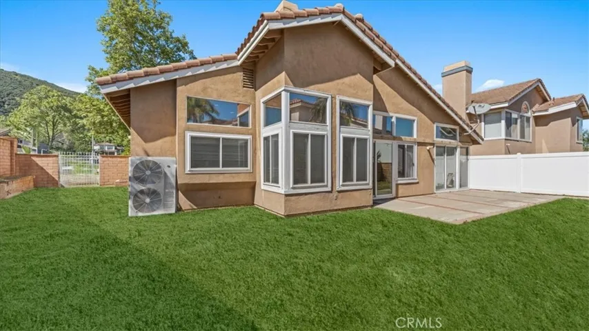 his outdoor space includes a concrete patio, grassy area, and direct access to the home, creating a functional extension of the living space.his outdoor space includes a concrete patio, grassy area, and direct access to the home, creating a functional extension of the living space.