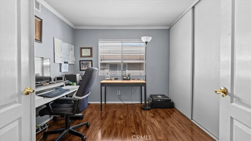 A versatile room with wood flooring and a window for natural light, perfect for use as a home office, guest room, or additional bedroom.