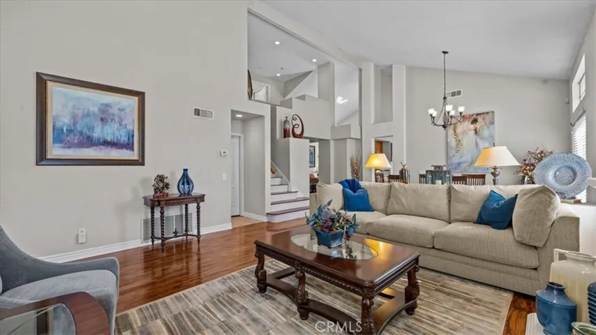 This open-concept living space connects effortlessly to the dining area and entryway, highlighted by high ceilings and natural light throughout.