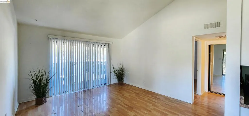 Empty room featuring light wood-style flooring and lofted ceiling