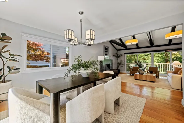 Dining room featuring light wood-type flooring, lofted ceiling with beams, and suspended lighting