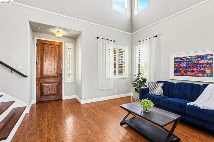 Living room with dark wood-type flooring and a high ceiling