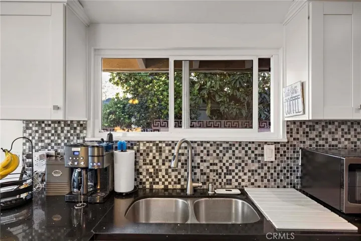 Remodeled kitchen with tiled backsplash.