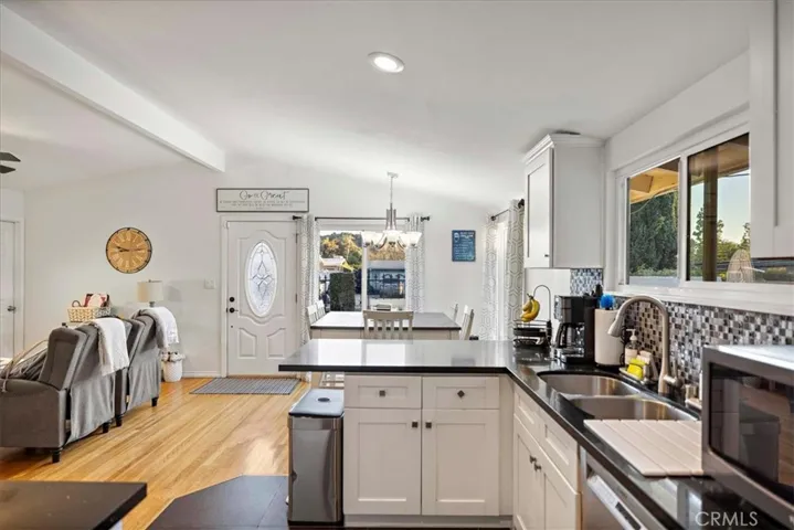 Remodeled kitchen with quartz countertops and decorative tile.