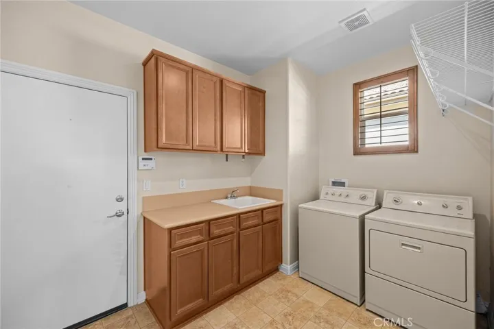 Spacious laundry room with cabinets and sink