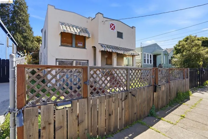 View of front of house with a fenced front yard, stucco siding, and a gate