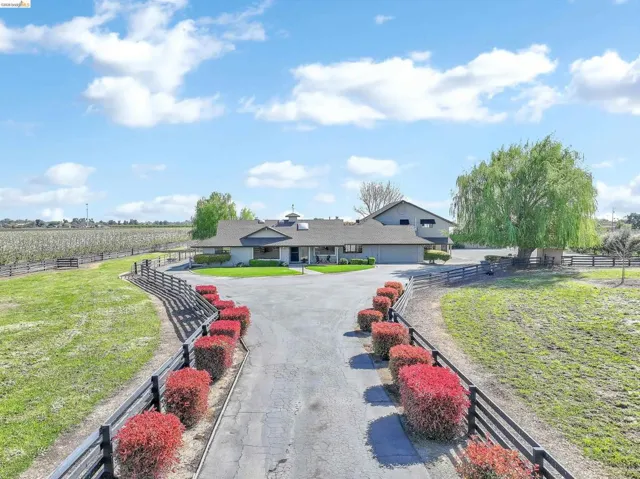 View of front facade with a fenced front yard, a view of countryside, and agricultural area