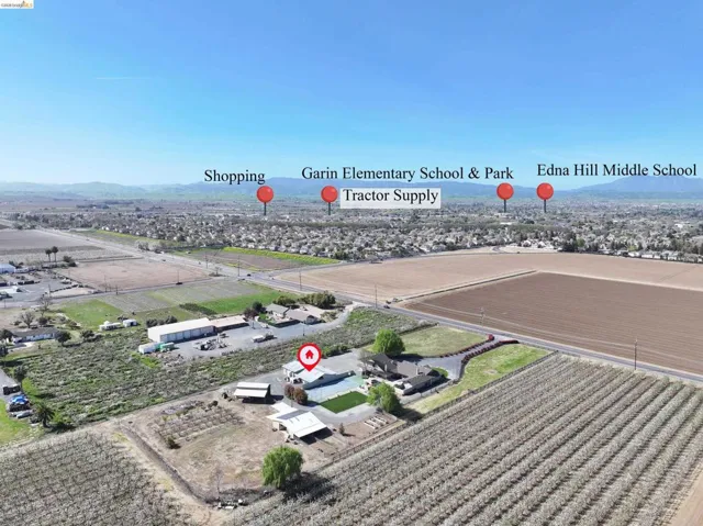 Aerial view of sparsely populated area featuring mountains and rows of crops