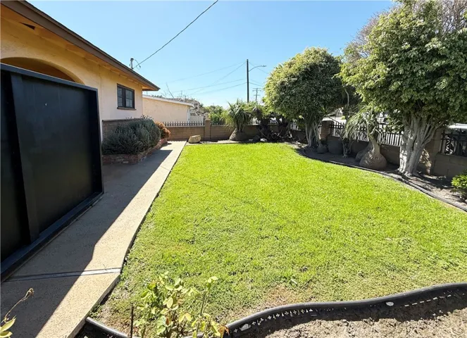 Professionally landscaped front yard with wrought iron fencing