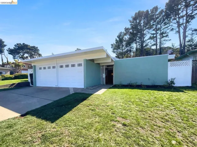 View of front of house featuring a front yard, stucco siding, a garage, and concrete driveway