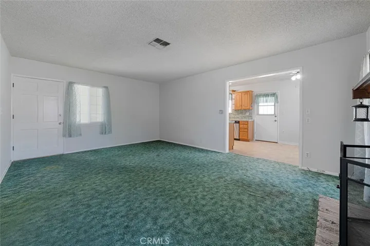 Spacious living room view to large kitchen.