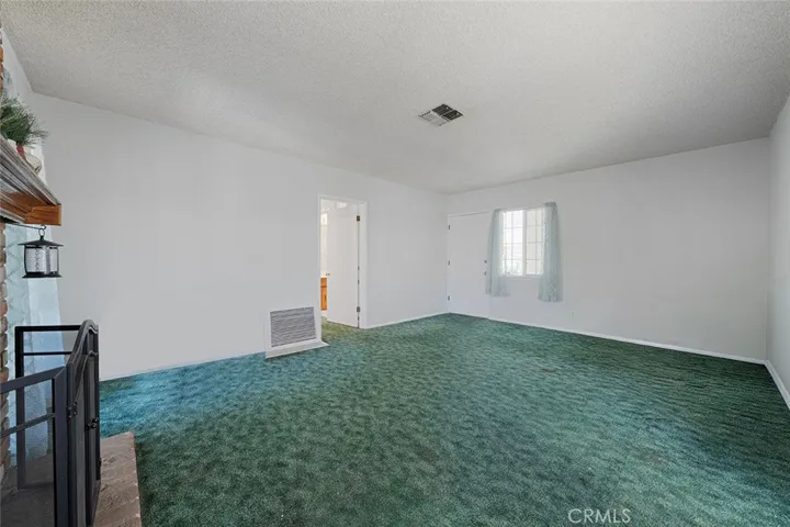 Living room from kitchen. House has central air conditioning and heating. Fresh paint. Long time carpet, raised foundation. Possible hardwood floors underneath carpet. Buyer to varify.