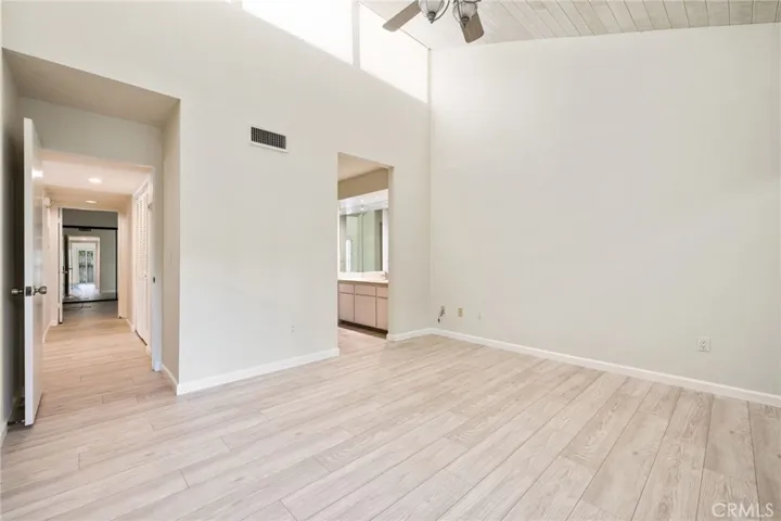 Primary bedroom, high ceilings and tons of light! View down the hall on left to 2nd bedroom.