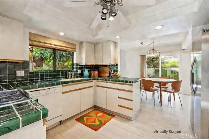 Kitchen with view out to the back patio. Virtually staged.