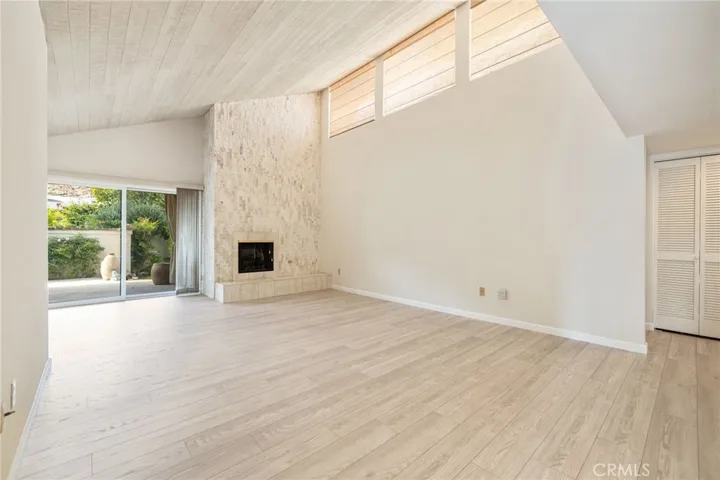 Living room with new floors, high ceilings and flooded with light.