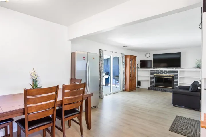 Dining space featuring light wood-type flooring and a brick fireplace