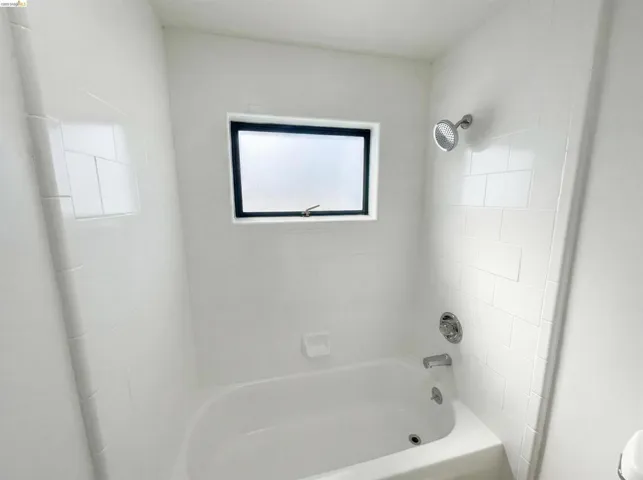 Bathroom featuring bathtub / shower combination and toilet