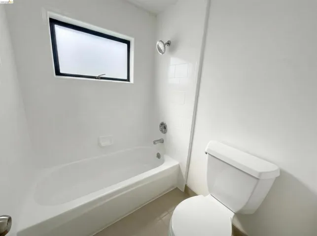 Bathroom featuring tub / shower combination and light tile patterned floors