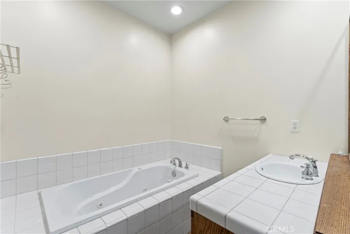 Primary ensuite bath with jetted tub, 2 sinks, shower, toilet