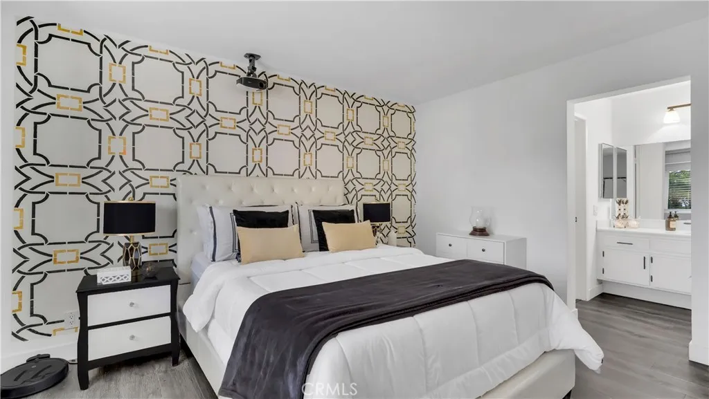 In the primary bedroom, a hand-stenciled designer accent wall adds a unique artistic touch you won’t see in other homes.
