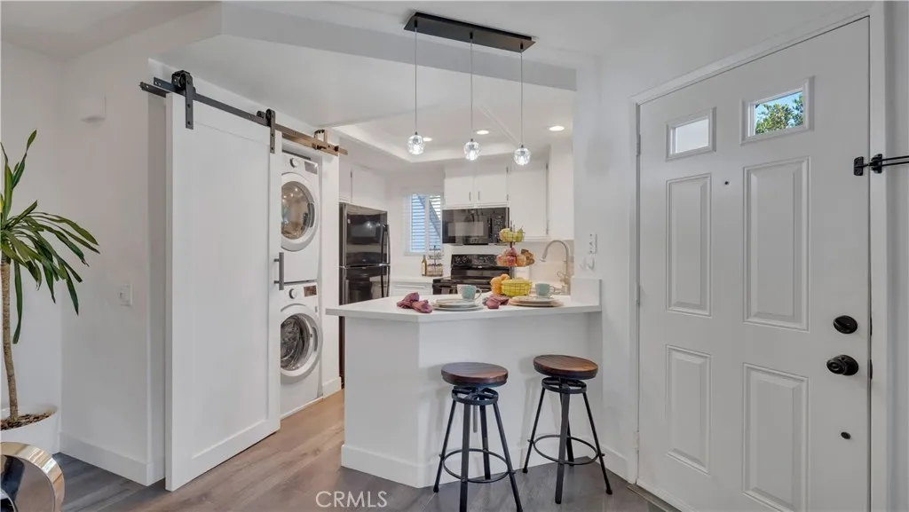The stackable washer and dryer are included and can easily be tucked away by a barn style door.